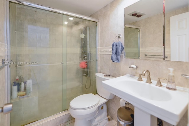 bathroom with sink, walk in shower, toilet, decorative backsplash, and tile walls