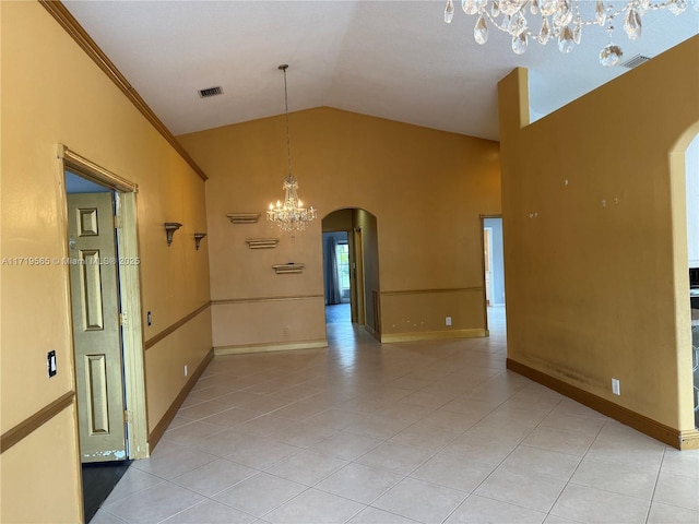 empty room with vaulted ceiling and light tile patterned floors