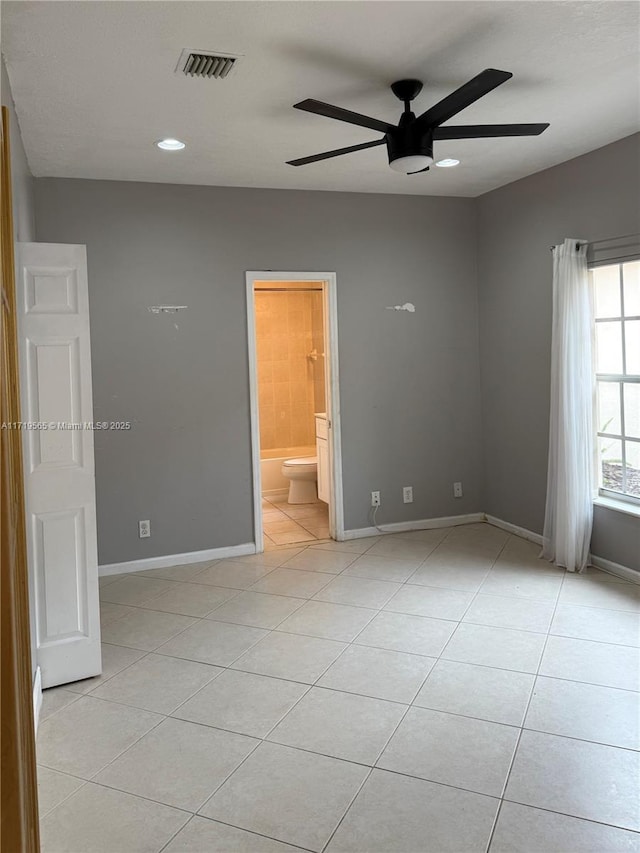 interior space with ensuite bathroom, ceiling fan, and light tile patterned floors