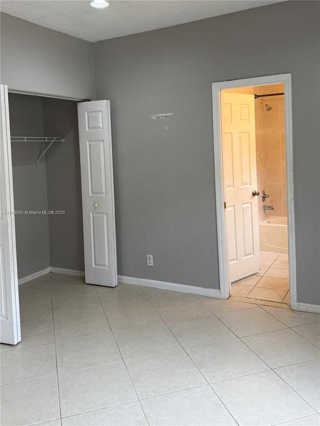 unfurnished bedroom with light tile patterned flooring and a closet