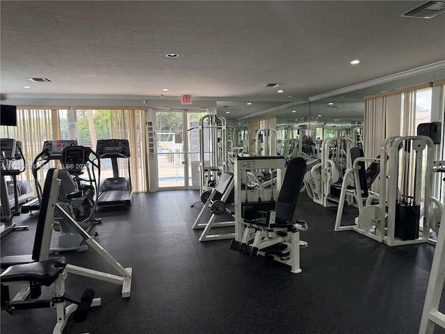 workout area featuring a textured ceiling and crown molding