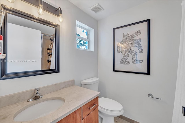 bathroom featuring tile patterned floors, vanity, toilet, and walk in shower