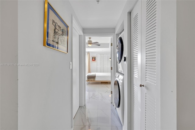 washroom featuring ceiling fan and stacked washing maching and dryer