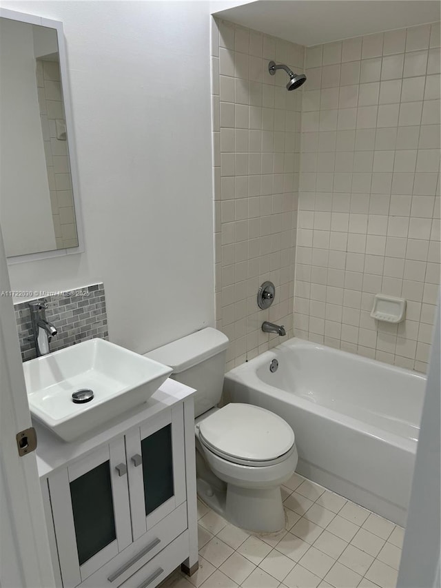 full bathroom featuring toilet, tasteful backsplash, tile patterned floors, tiled shower / bath, and vanity