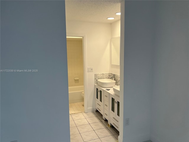 bathroom featuring a textured ceiling, vanity, tile patterned floors, and toilet