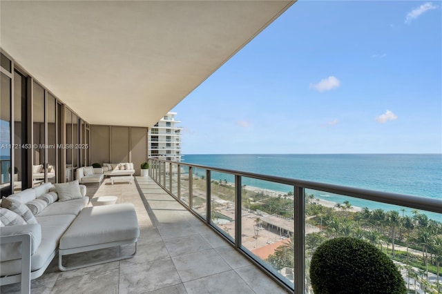 balcony with a water view, outdoor lounge area, and a beach view