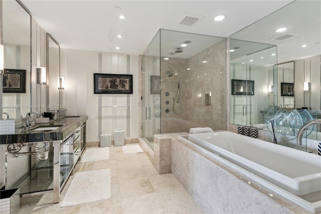 bathroom with vanity and shower with separate bathtub