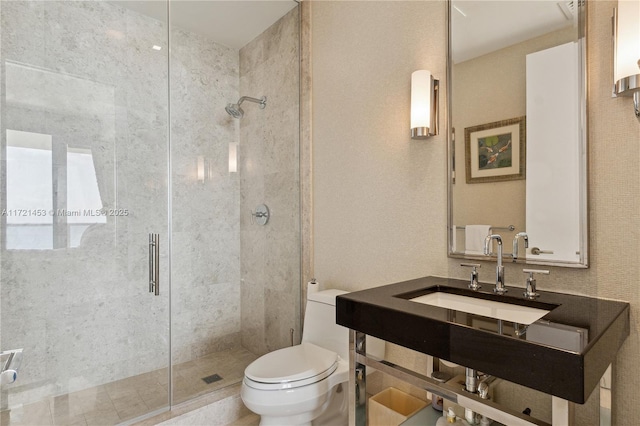 bathroom featuring sink, toilet, and a shower with door