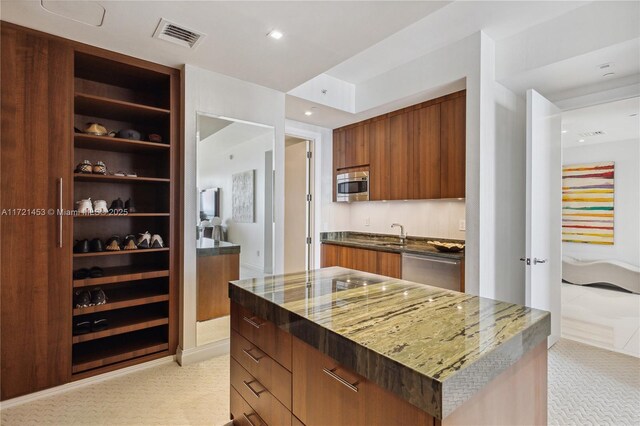 kitchen with sink, appliances with stainless steel finishes, and a kitchen island