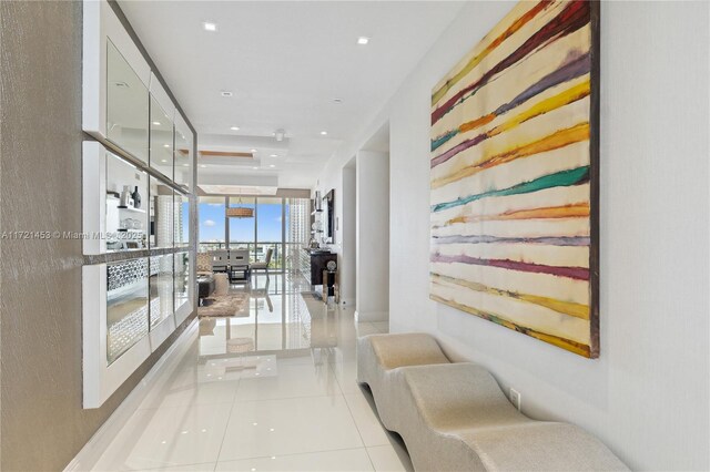 hall with light tile patterned floors and floor to ceiling windows