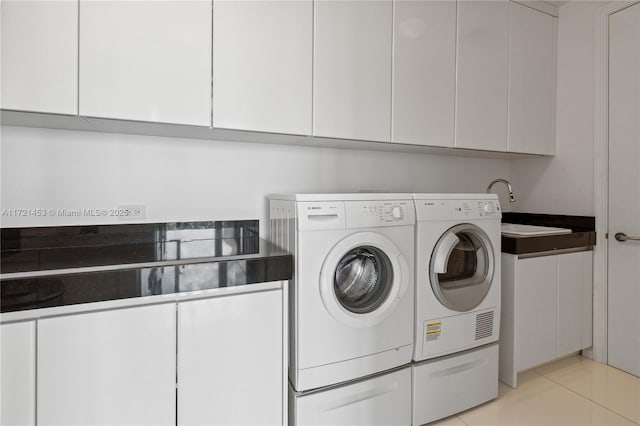 clothes washing area with sink, independent washer and dryer, cabinets, and light tile patterned floors