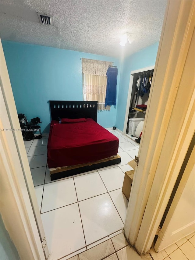 bedroom featuring tile patterned floors and a textured ceiling