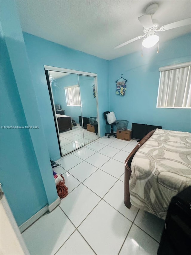 bedroom featuring tile patterned flooring, ceiling fan, and a closet