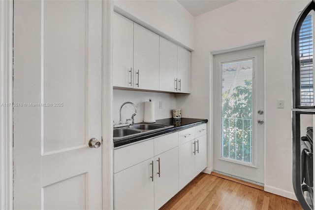 bar featuring plenty of natural light, white cabinetry, and sink