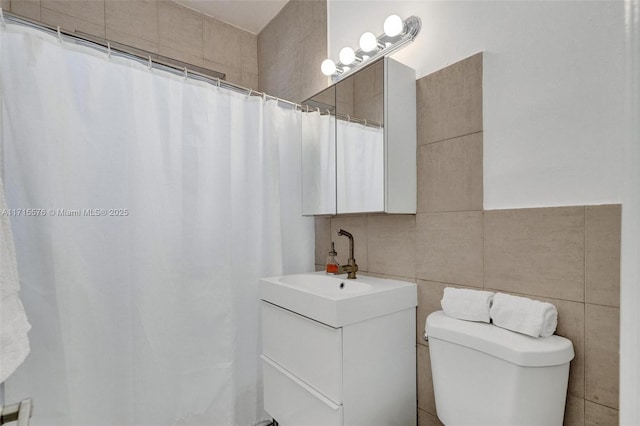 bathroom featuring a shower with curtain, vanity, tile walls, and toilet