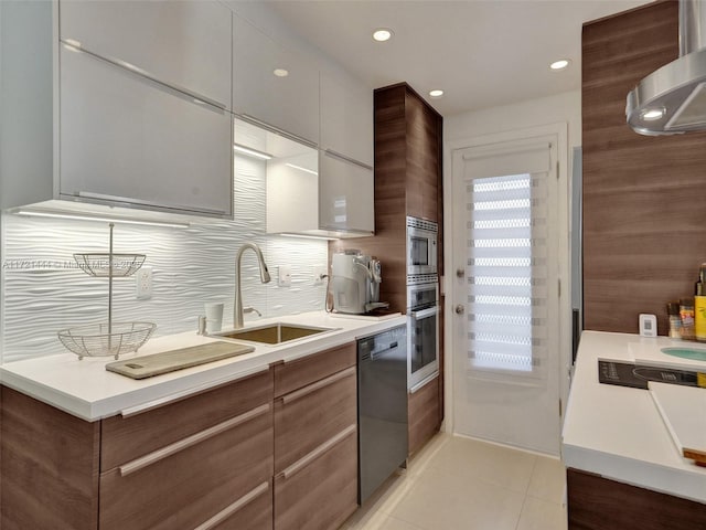 kitchen featuring decorative backsplash, appliances with stainless steel finishes, exhaust hood, sink, and light tile patterned floors