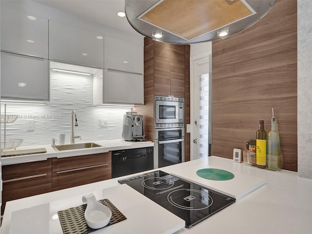 kitchen featuring backsplash, sink, white cabinets, and black appliances