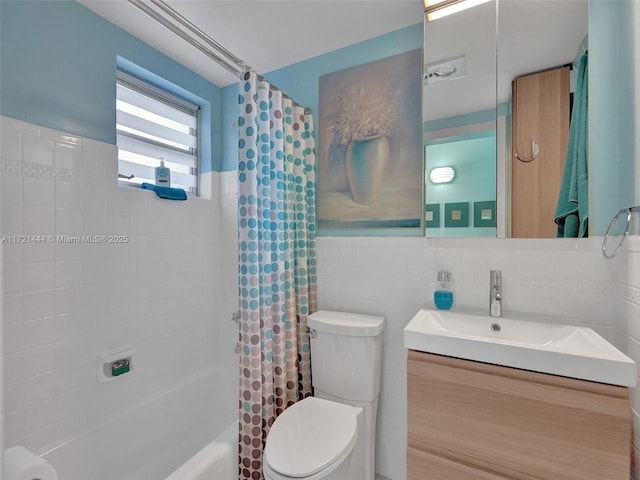 full bathroom featuring vanity, toilet, tile walls, tasteful backsplash, and shower / tub combo