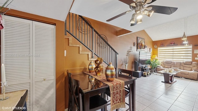 tiled dining room with ceiling fan and lofted ceiling