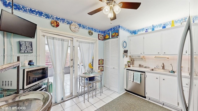 kitchen with dishwasher, white cabinets, light tile patterned flooring, and sink