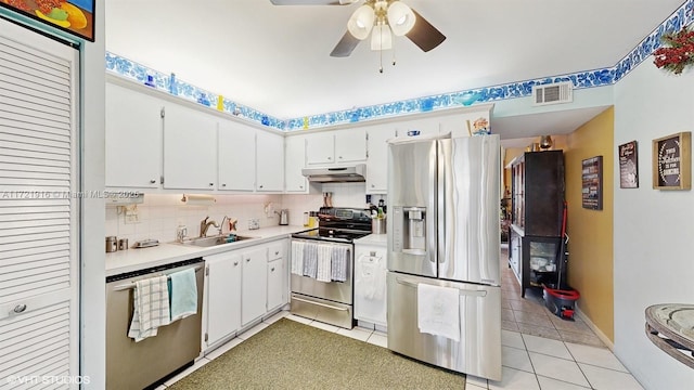 kitchen featuring backsplash, sink, light tile patterned flooring, white cabinetry, and stainless steel appliances