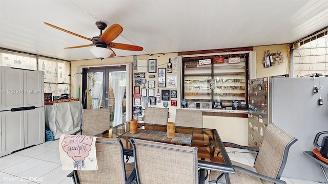 tiled dining area with ceiling fan and french doors