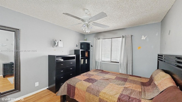 bedroom featuring hardwood / wood-style floors, ceiling fan, and a textured ceiling