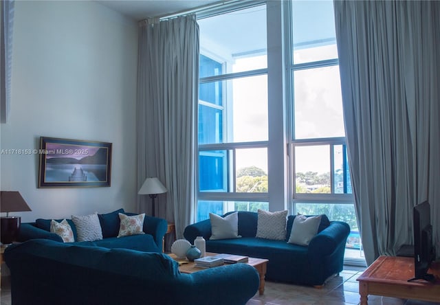 living room with light tile patterned floors and a wall of windows