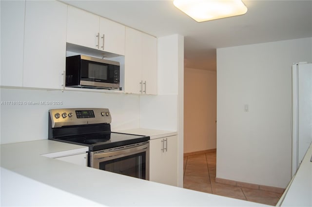 kitchen featuring white cabinets, light tile patterned floors, and stainless steel appliances