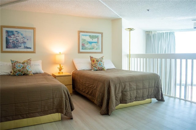 bedroom with light hardwood / wood-style floors and a textured ceiling