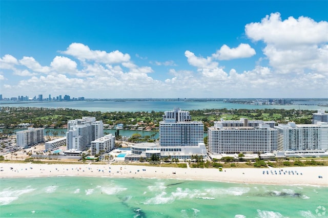 birds eye view of property with a water view and a beach view