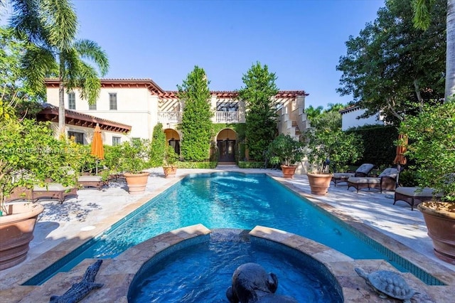 view of swimming pool with an in ground hot tub and a patio