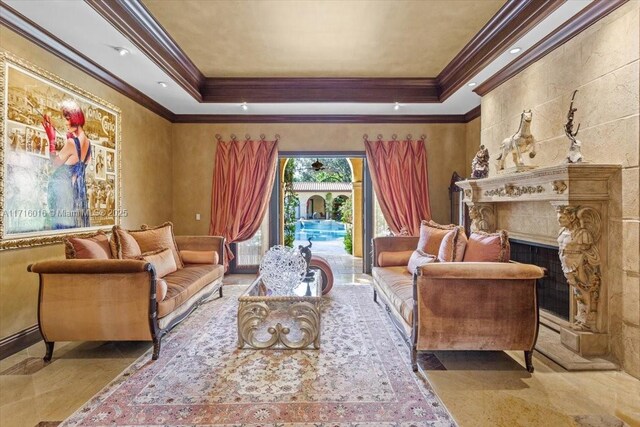 living area with a raised ceiling, a high end fireplace, and ornamental molding