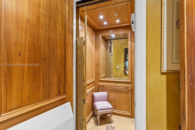 room details featuring elevator, wood walls, and wood ceiling