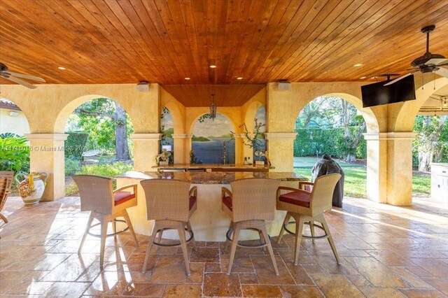 view of patio featuring ceiling fan and exterior bar