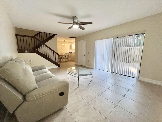 living room featuring light tile patterned floors and ceiling fan with notable chandelier