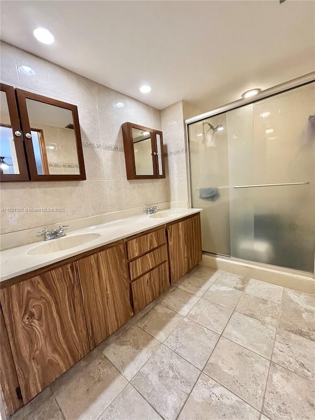 bathroom featuring backsplash, vanity, tile walls, and walk in shower