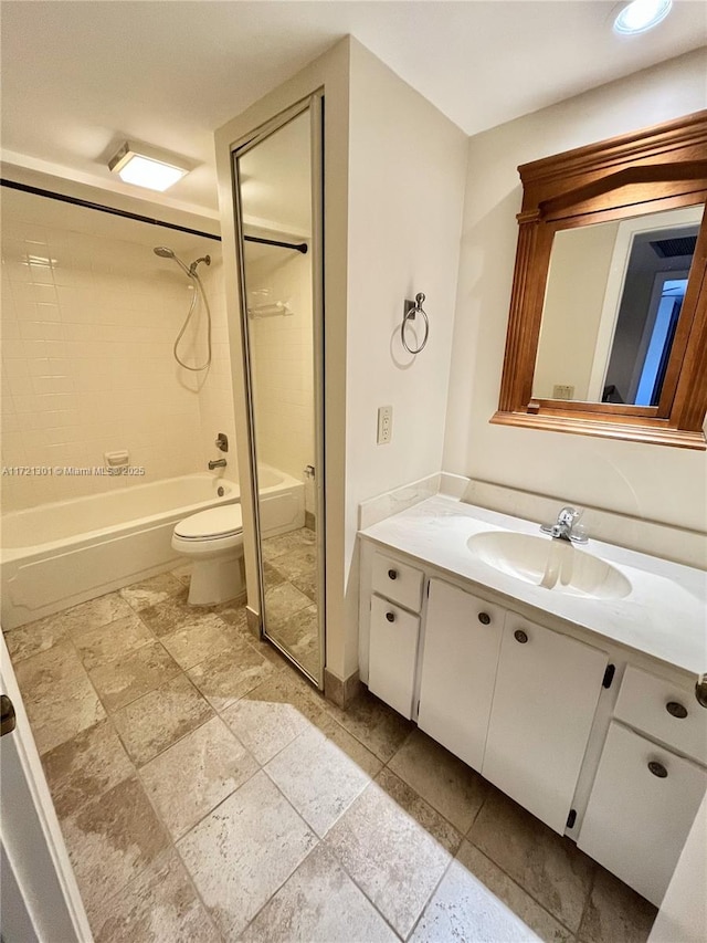 full bathroom with vanity, tiled shower / bath combo, and toilet