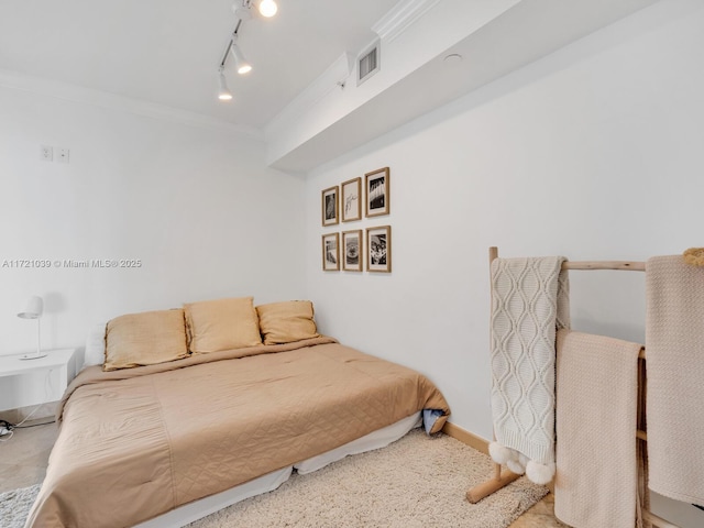 bedroom with crown molding and track lighting