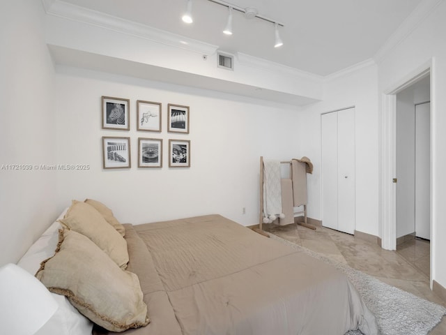 bedroom featuring rail lighting, a closet, and crown molding