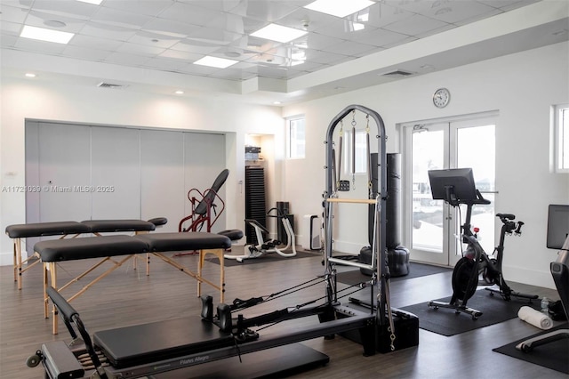 workout area featuring a paneled ceiling and hardwood / wood-style floors