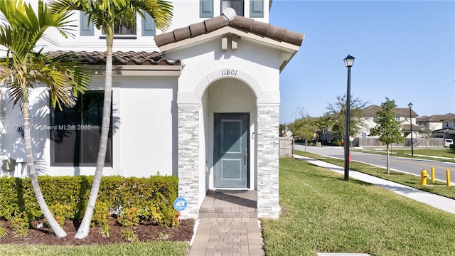 entrance to property with a lawn