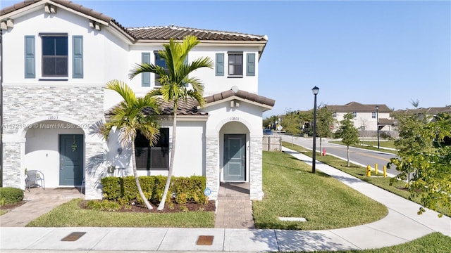 mediterranean / spanish house with a front yard