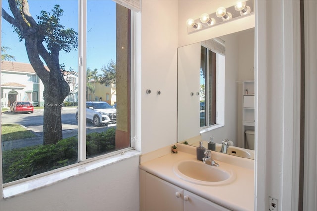 bathroom with toilet, plenty of natural light, and vanity