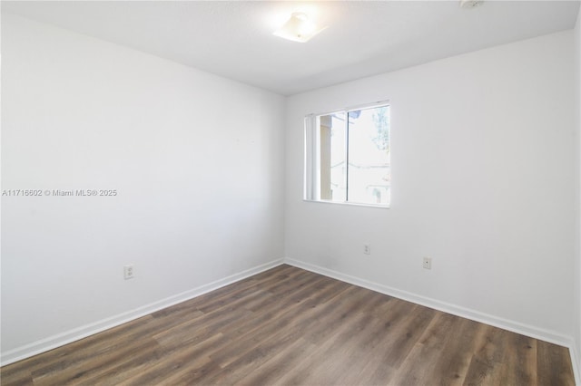 unfurnished room featuring dark wood-style floors and baseboards