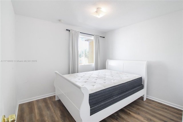 bedroom featuring baseboards and wood finished floors