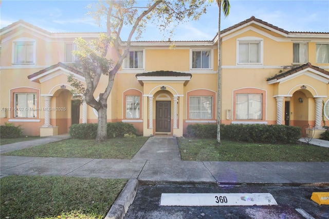 multi unit property with a tile roof and stucco siding