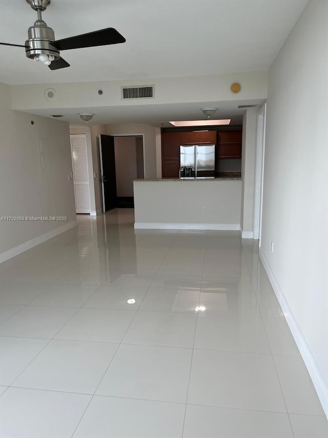 spare room featuring ceiling fan and light tile patterned floors