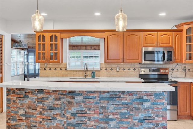 kitchen featuring a healthy amount of sunlight, appliances with stainless steel finishes, sink, and light tile patterned flooring