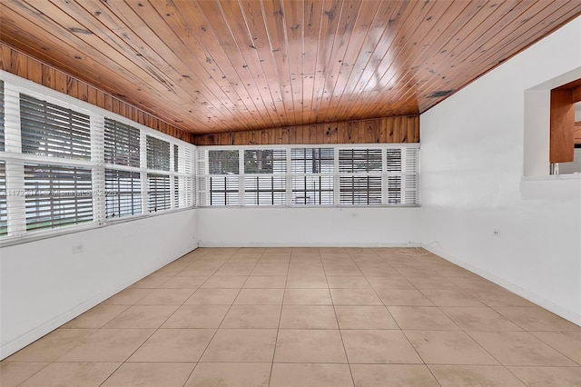 tiled spare room featuring wooden ceiling